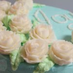 Cake with Tiffany Blue buttercream icing, flowers and word Joy