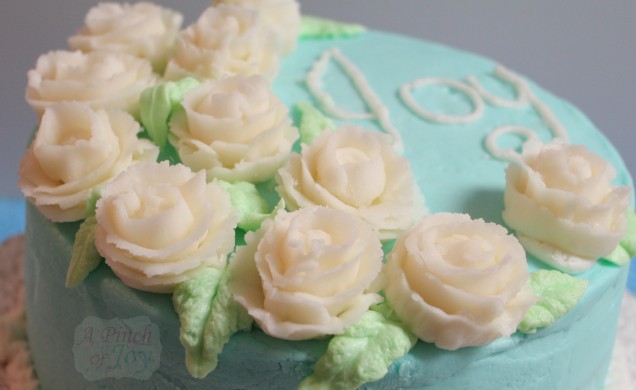 Cake with Tiffany Blue frosting, flowers and word Joy