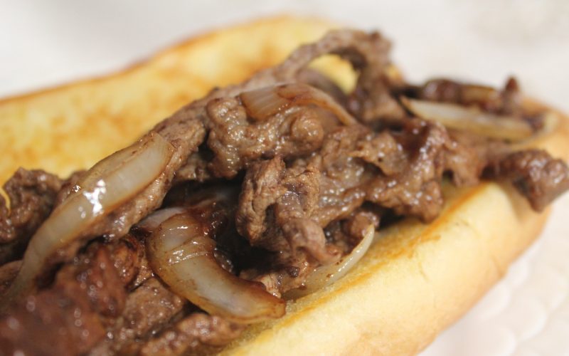 Beef and onion on a toasted bun sandwich