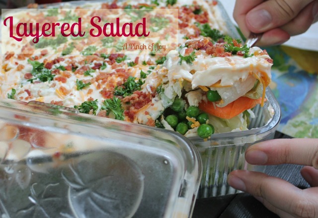 Lettuce salad layered with other vegetables and topped with mayo